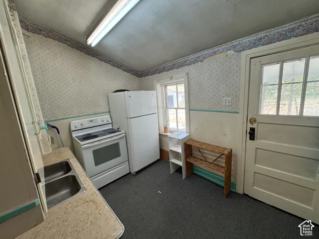 Kitchen featuring a stainless steel double basin sink, white electric range, and a white refrigerator