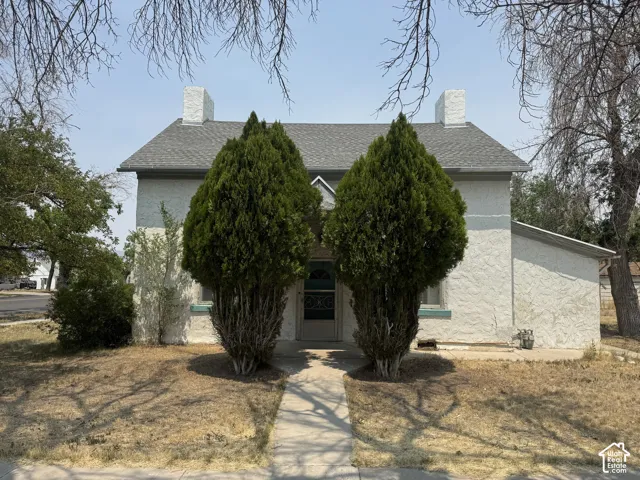 Stucco exterior with a pitched shingle roof