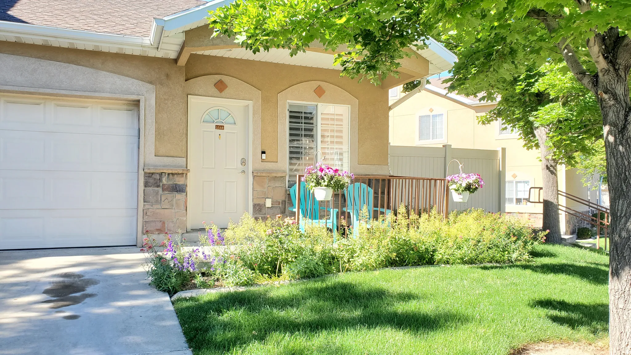 Stucco exterior featuring a single-car garage, stone accents, and a covered porch