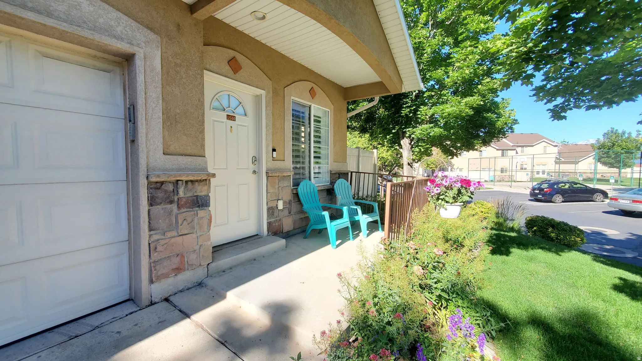 Inviting front entry featuring a stone facade accent, covered porch, and an attached garage