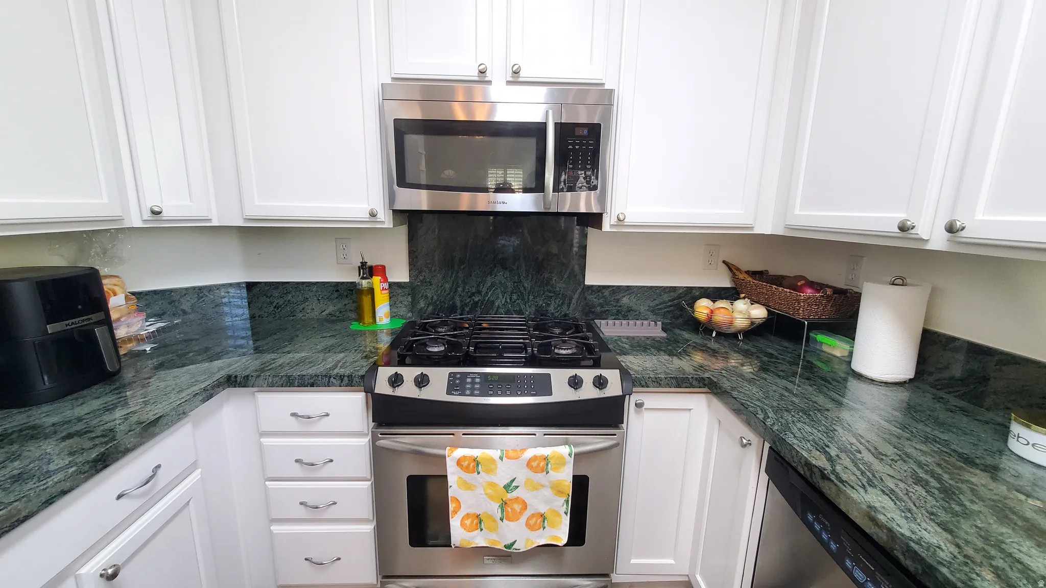 Kitchen featuring white cabinetry and dark green patterned countertops