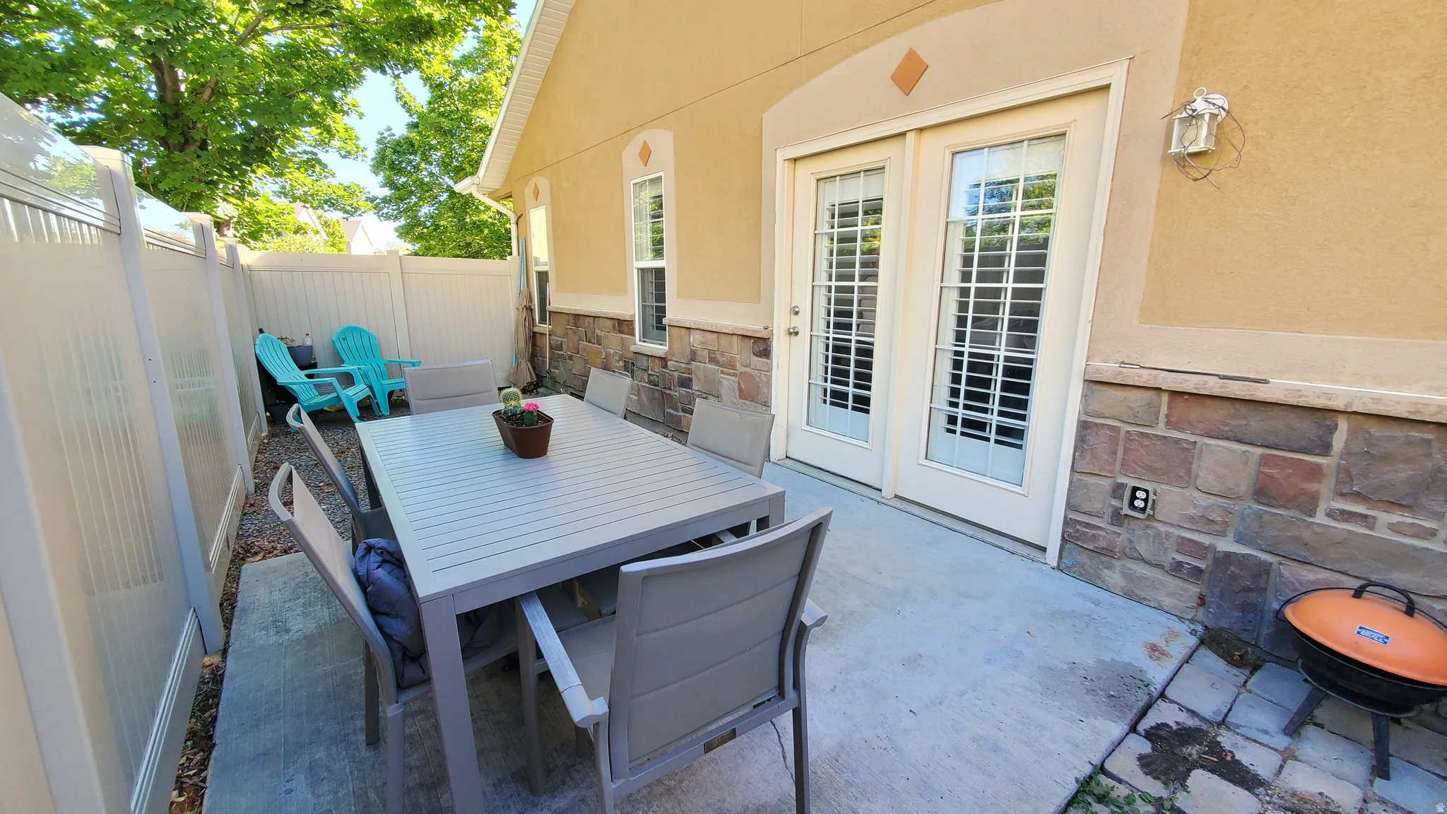 Private outdoor patio featuring a concrete slab and stone accent wall