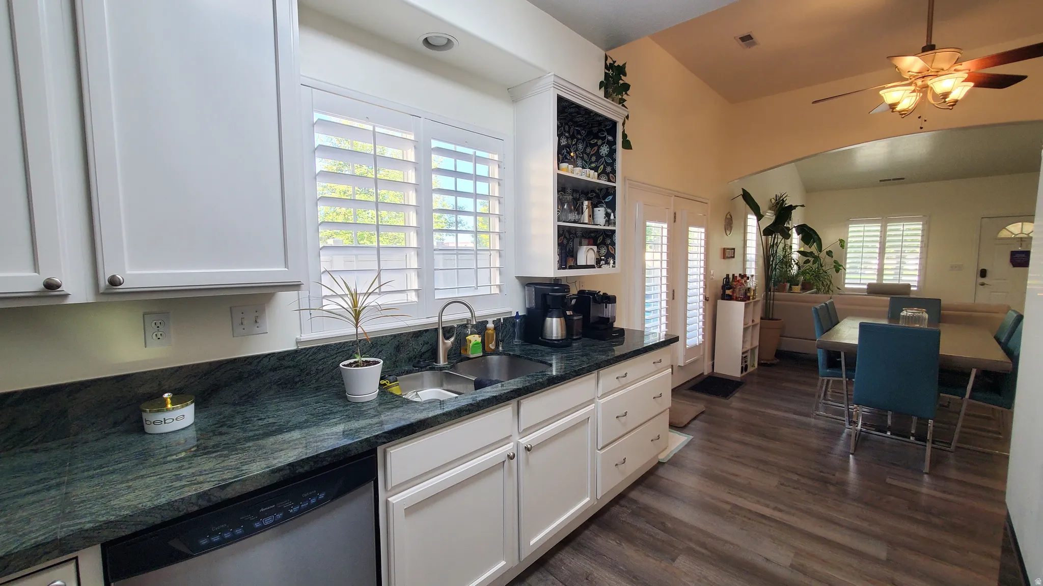 Kitchen with white cabinetry, dark stone countertops, and a stainless steel sink