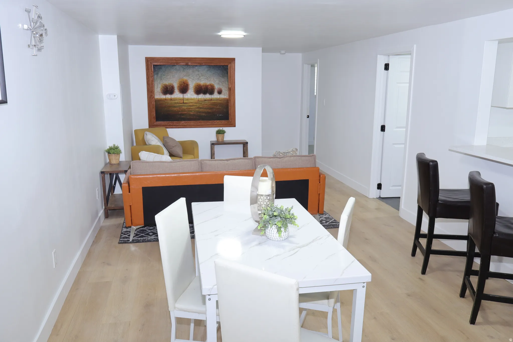 Open-concept living area featuring light wood-finish flooring, white walls, and recessed lighting