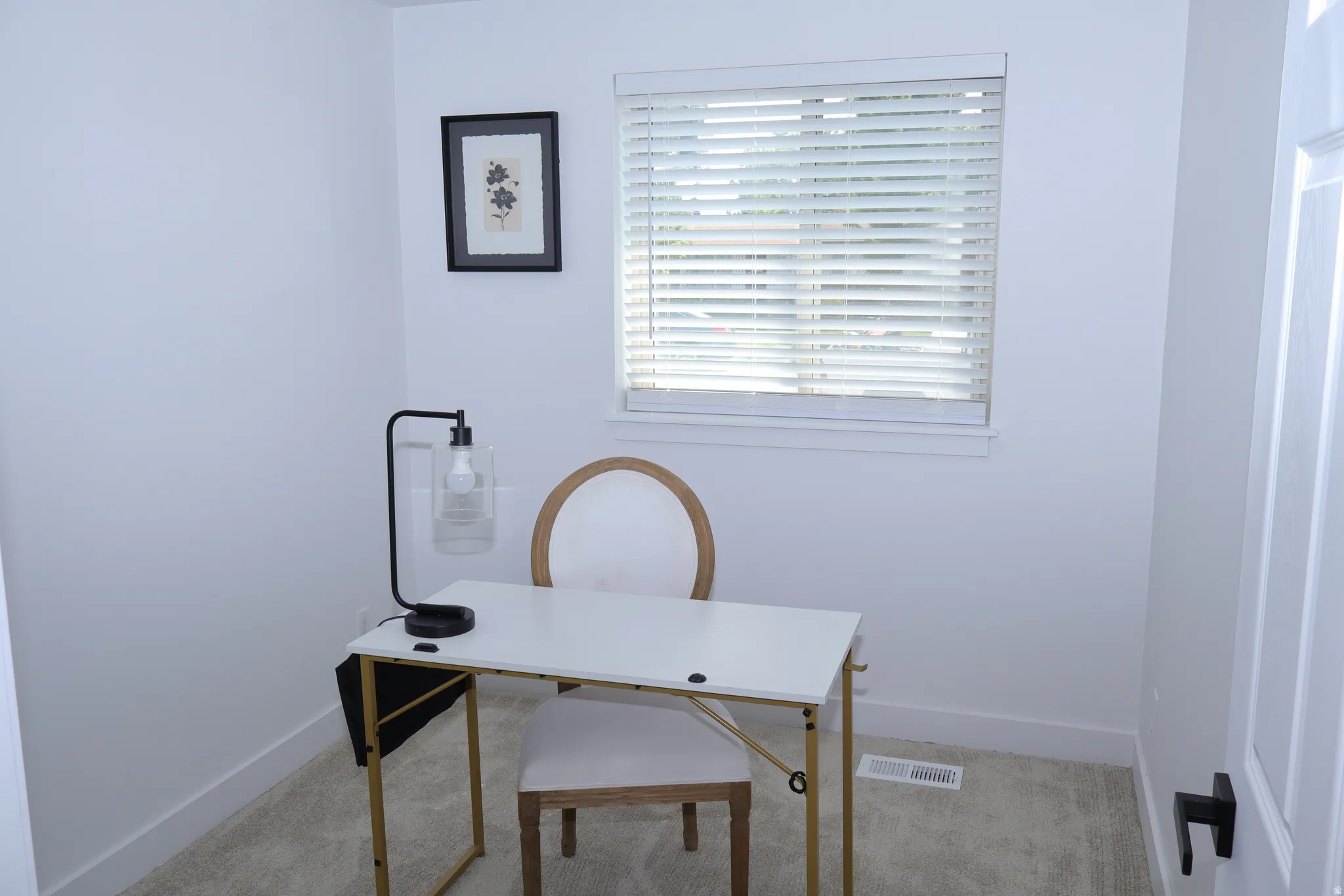 Bright room with a single window featuring horizontal blinds