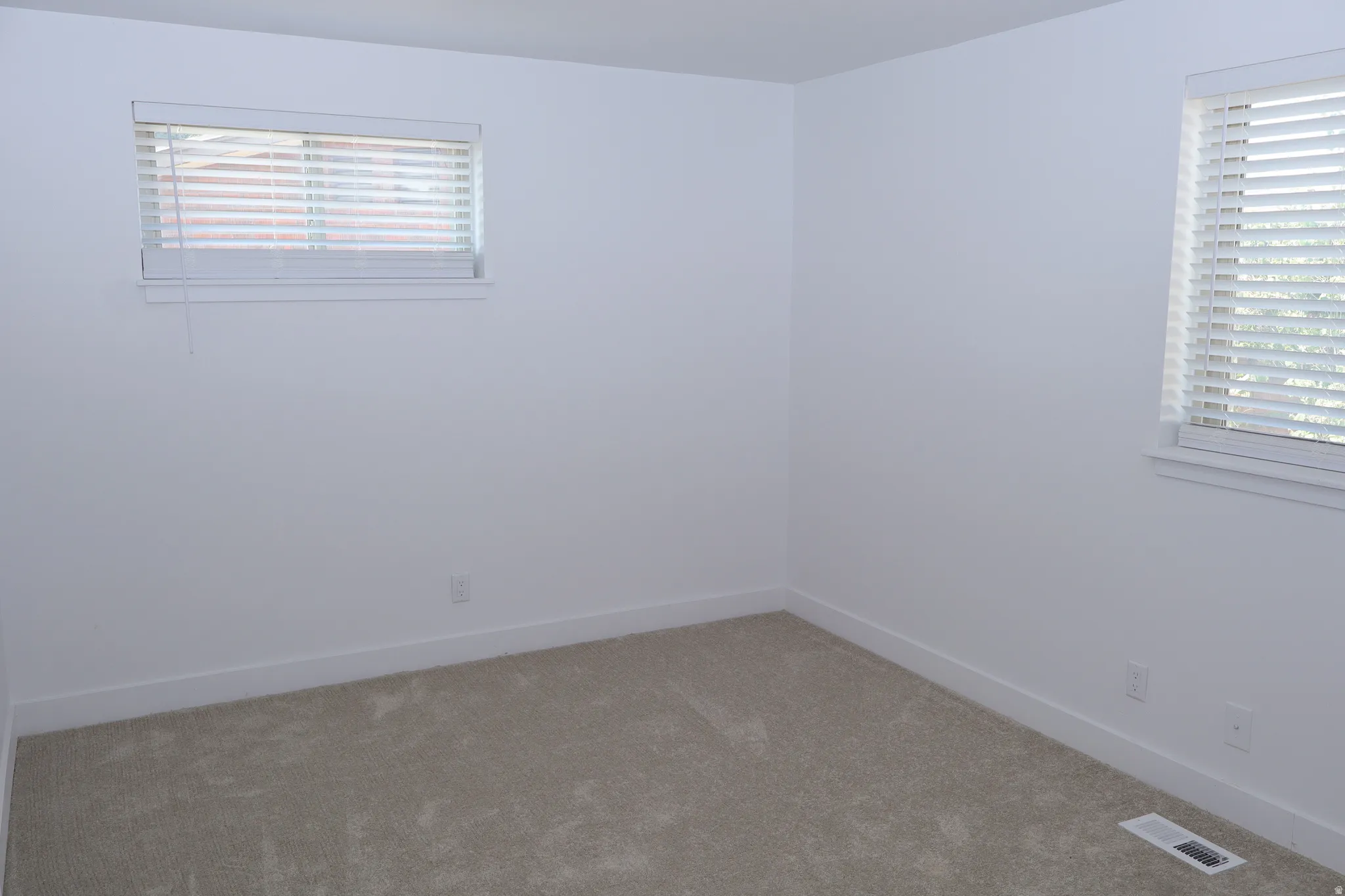 Neutral-toned wall-to-wall carpeting complements the bright white walls and trim
