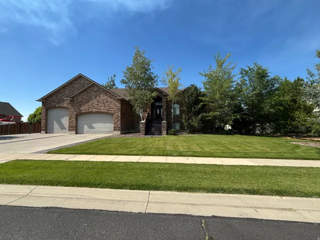 Brick-front residence with a two-car garage featuring arched doors