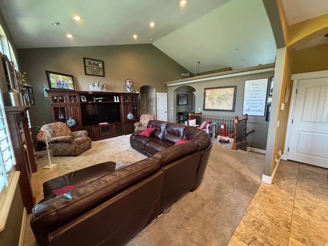 Open-concept living space with a vaulted ceiling and recessed lighting