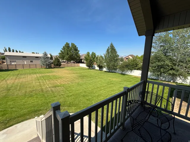 Expansive lawn area with mature trees, surrounded by fencing