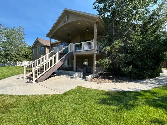 Expansive concrete patio with direct access to a covered upper deck and lower-level outdoor space