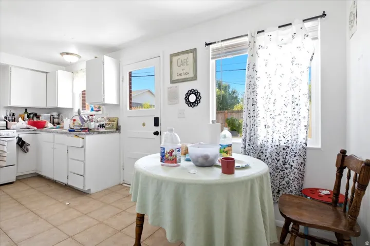 Kitchen featuring white cabinetry, light-toned countertop, and tile flooring