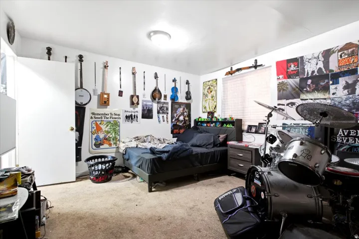 Carpeted room featuring white walls and a ceiling-mounted light fixture