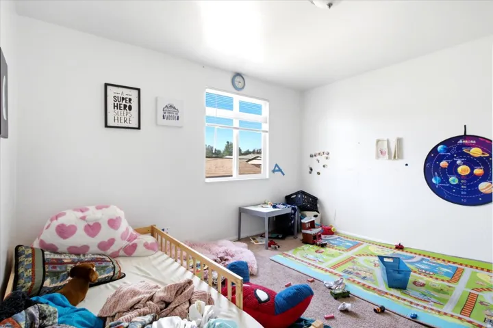 Bright room with white painted walls, a single window with horizontal blinds, and a flush-mount ceiling light fixture