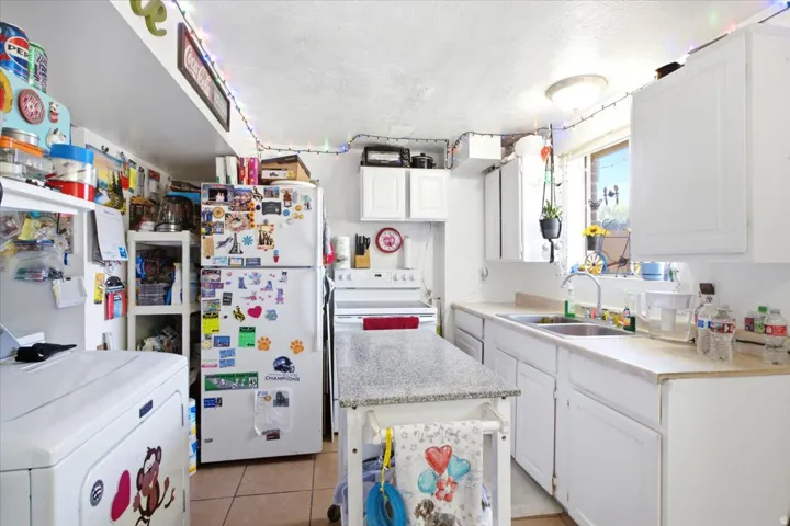 Kitchen featuring white cabinetry, a double basin stainless steel sink, and a window with natural light