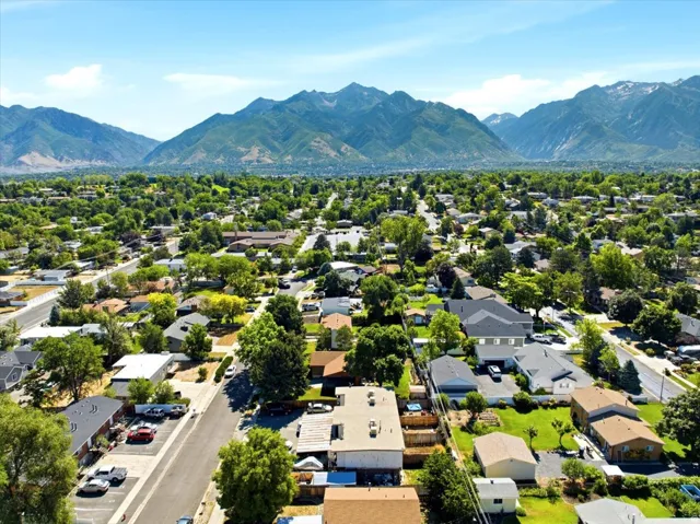 Expansive residential area featuring numerous mature trees and mountain ranges in the background