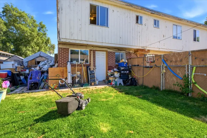 Fenced backyard featuring mature landscaping, a manicured lawn, and a wooden privacy fence