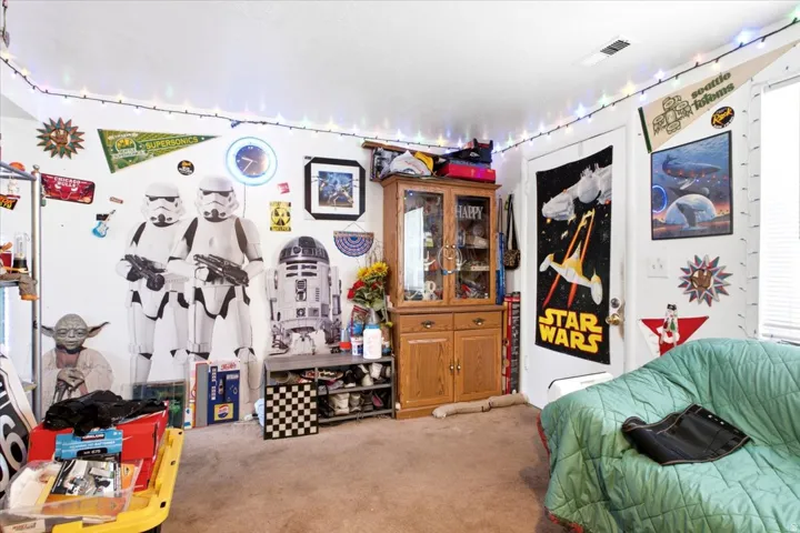 Room with light brown carpet flooring, a white ceiling with a ceiling fan, and white walls