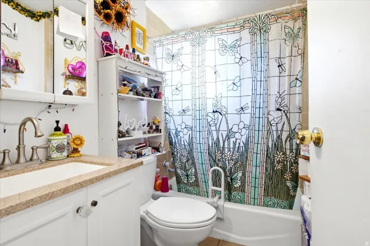 White vanity with crystal-style knobs, a light-toned countertop, and a brushed nickel faucet