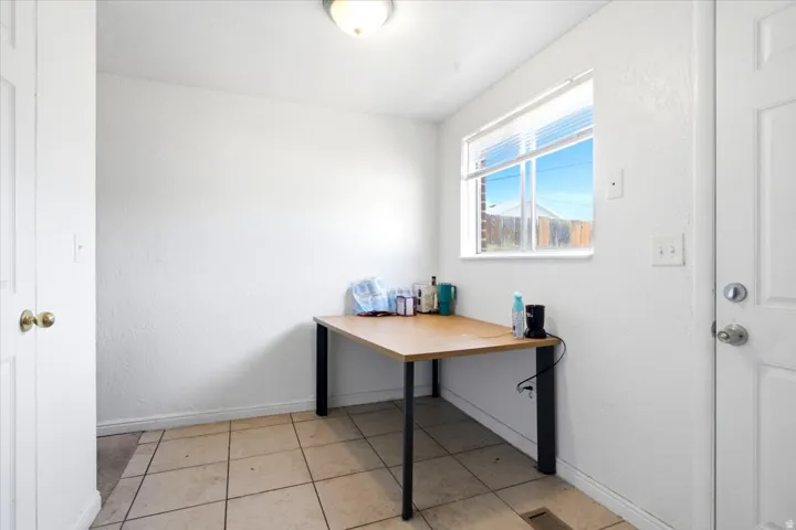 Bright room featuring a window with blinds, tile flooring, and a flush mount ceiling light fixture