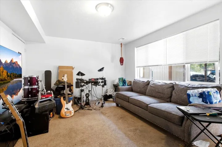 Spacious room featuring broad windows with blinds, a ceiling-mounted light fixture, and neutral-toned wall paint