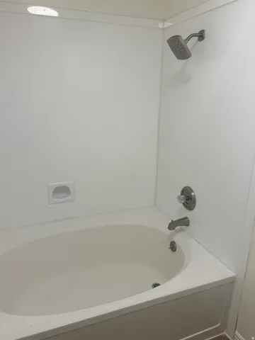 White tub and shower combination with chrome fixtures