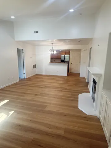 Open-concept living area with wood-finish flooring, vaulted ceilings, and recessed lighting