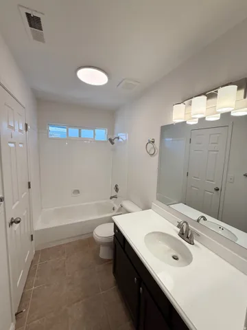 Bathroom featuring a single vanity, undermount sink, dark wood-finish cabinetry, and a shower-tub combination