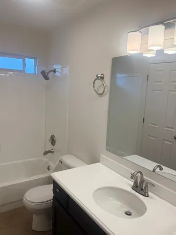 Bathroom featuring a white vanity with a rectangular sink, brushed nickel faucet, and a large wall mirror