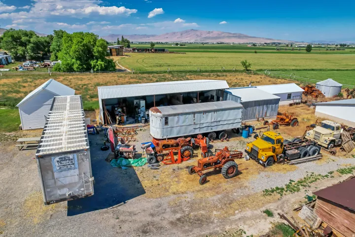 Expansive property featuring multiple outbuildings, including a large shed with a metal roof and a separate storage structure