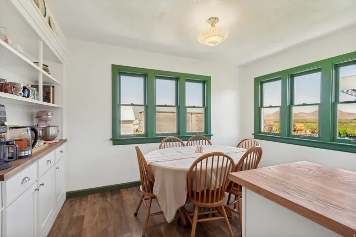 Dining area featuring wood-finish flooring and ample natural light through multiple windows with green trim