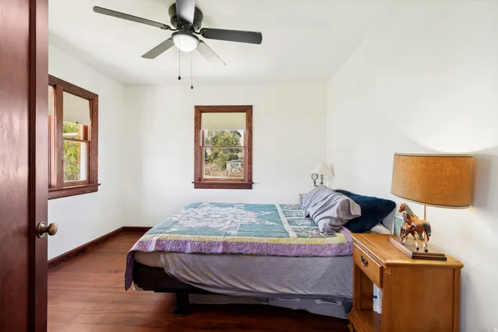 Hardwood-finish flooring featuring two double-hung windows with natural wood trim