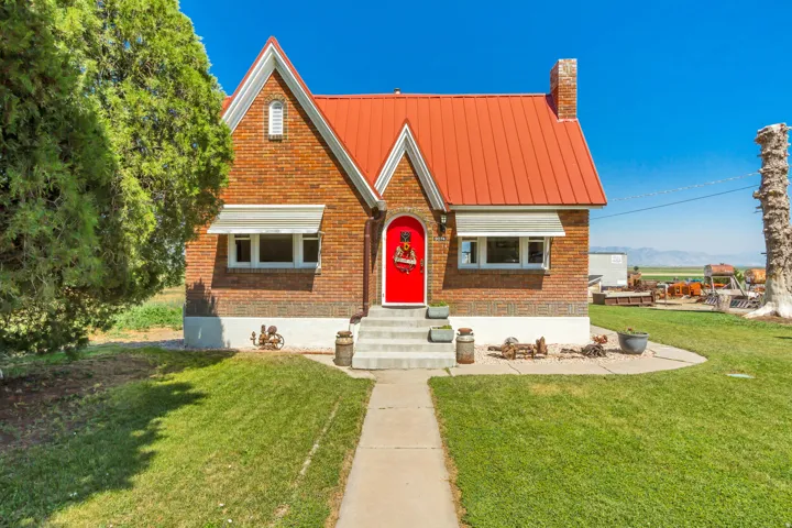 Brick exterior featuring a bright red front door with a metal roof