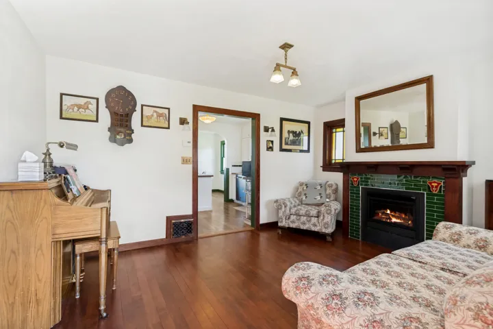Fireplace featuring green subway tile surround and wood mantel