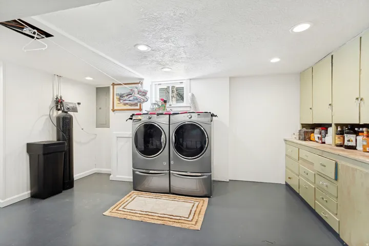 Dedicated utility space featuring a water treatment system and recessed lighting
