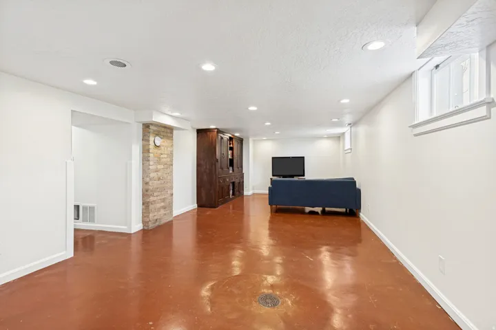 Spacious lower level featuring warm-toned flooring, recessed lighting, and white painted walls