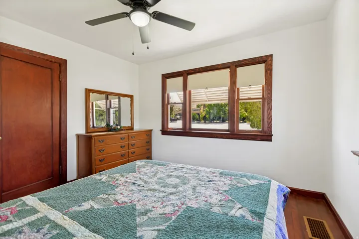 Interior room featuring wood-finish flooring, a ceiling fan with integrated lighting, and white walls