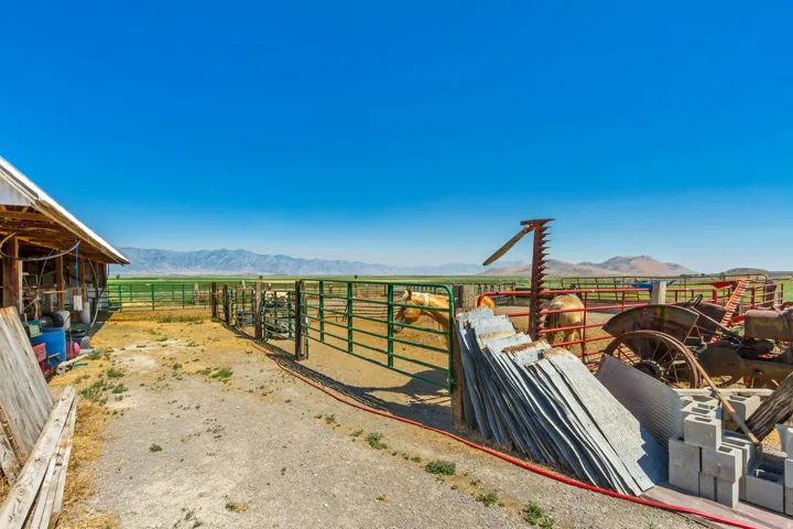 Expansive outdoor area with a barn structure and metal fencing _