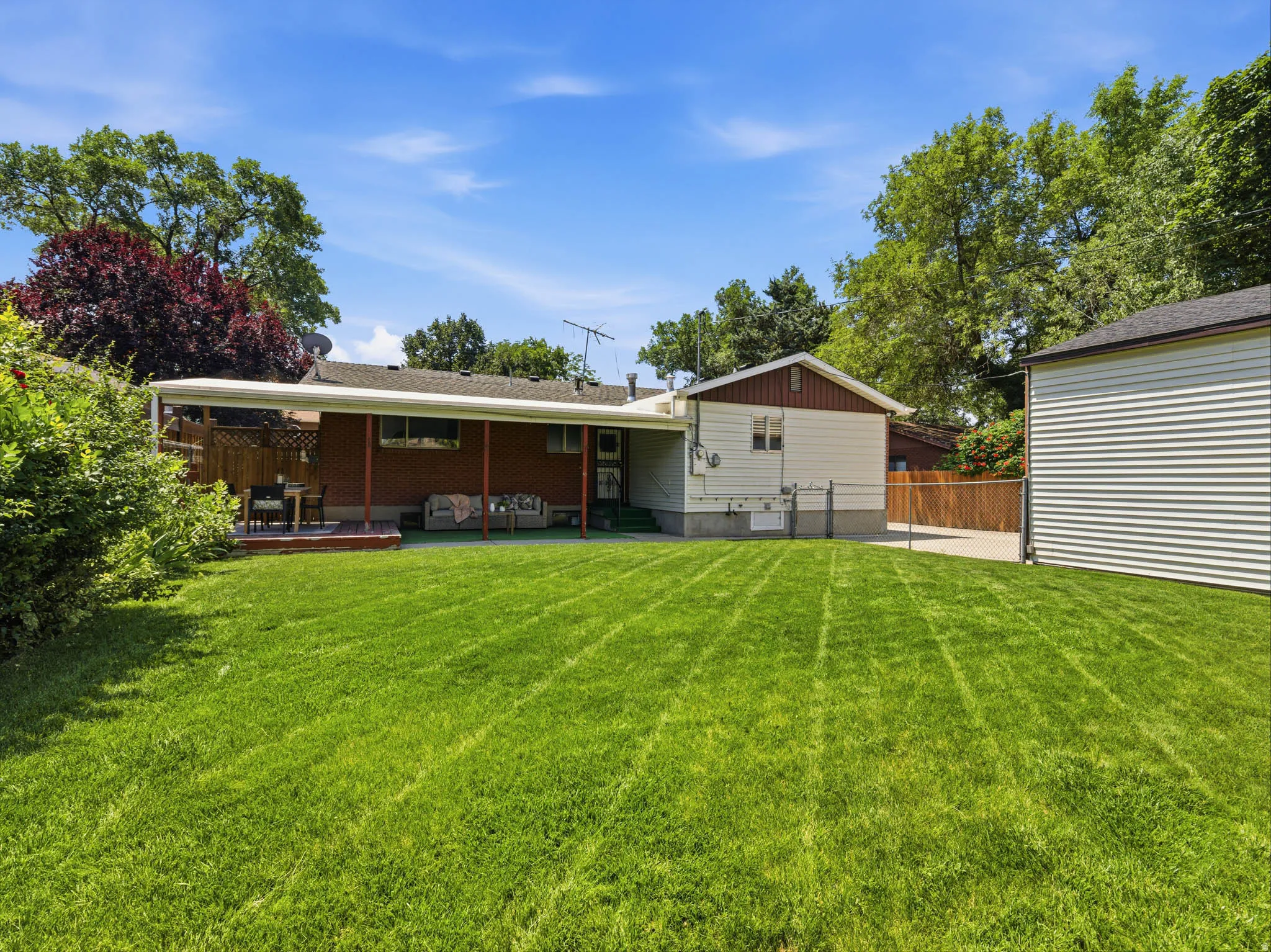 Expansive green lawn with mature perimeter trees