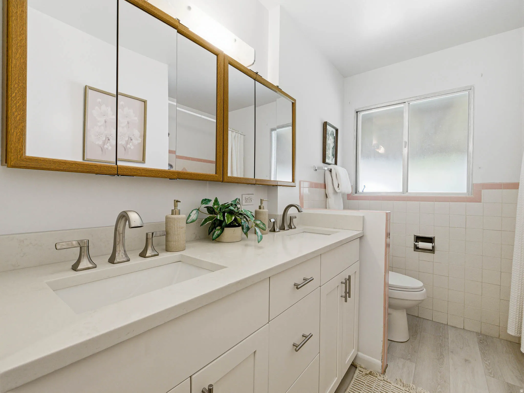 Dual vanity with integrated sinks, brushed nickel fixtures, and white cabinetry