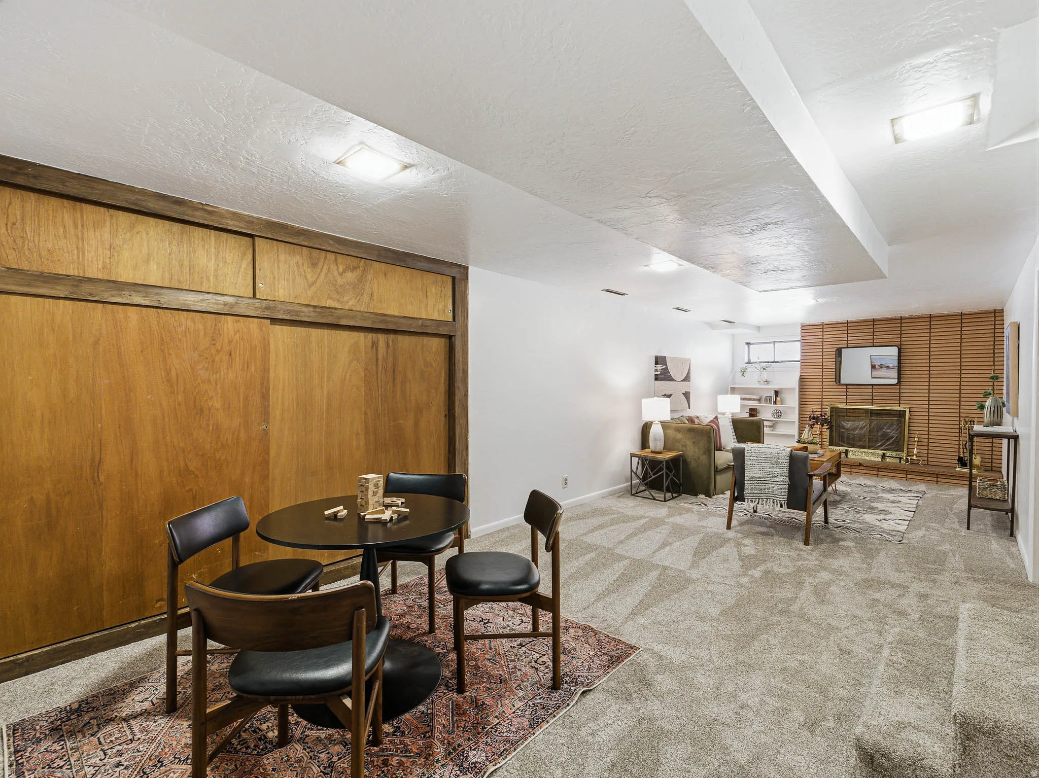 Spacious lower-level area with wood paneling and recessed lighting