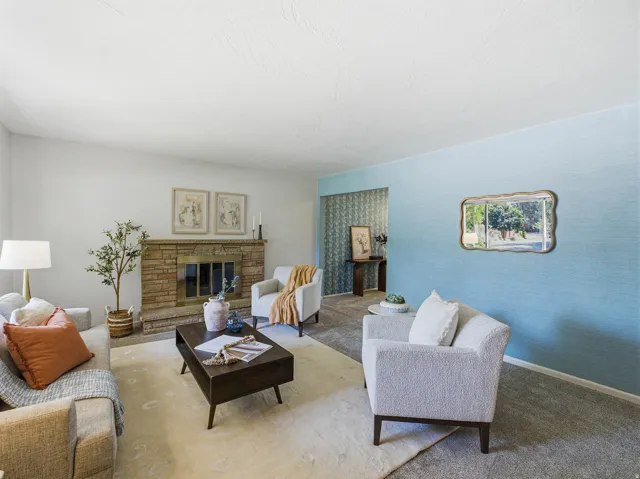 Living area featuring a stone fireplace with a brass firebox, light-colored walls, and textured blue accent wall