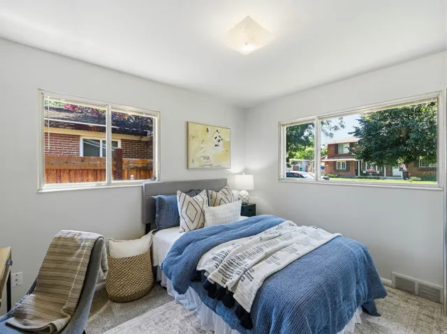 Bright room featuring two large windows, white walls, and light-toned carpeting