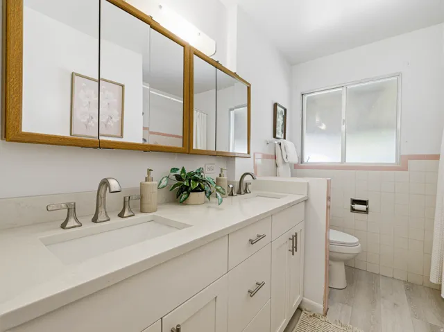Dual vanity with integrated sinks, brushed nickel fixtures, and white cabinetry