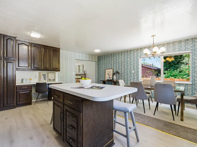 Kitchen with a central island featuring a white countertop and dark wood cabinetry