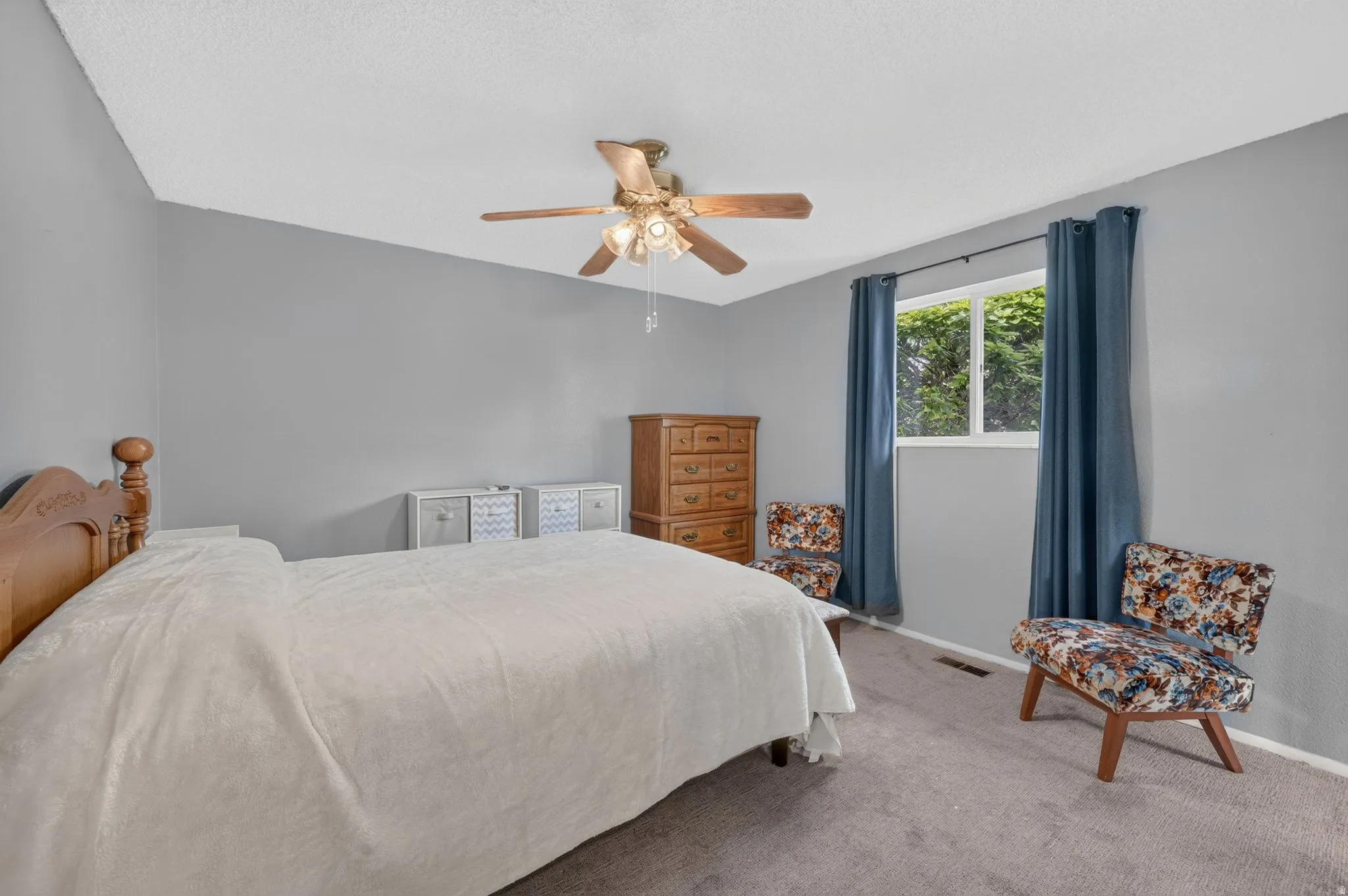 Interior room featuring neutral wall paint, a window with natural light, and a ceiling fan with integrated lighting