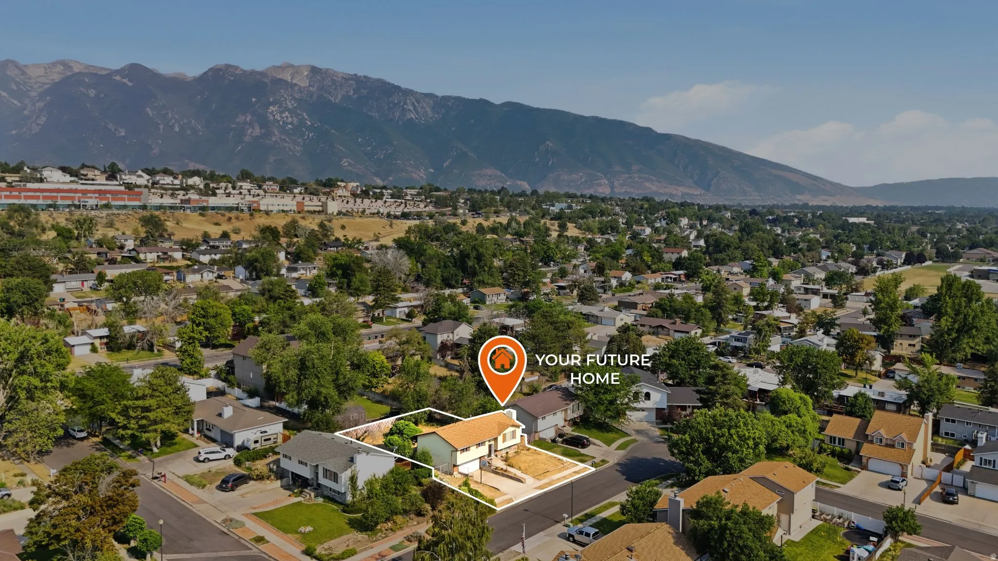 Aerial perspective showcasing a residential property with a light-colored exterior and a prominent front yard