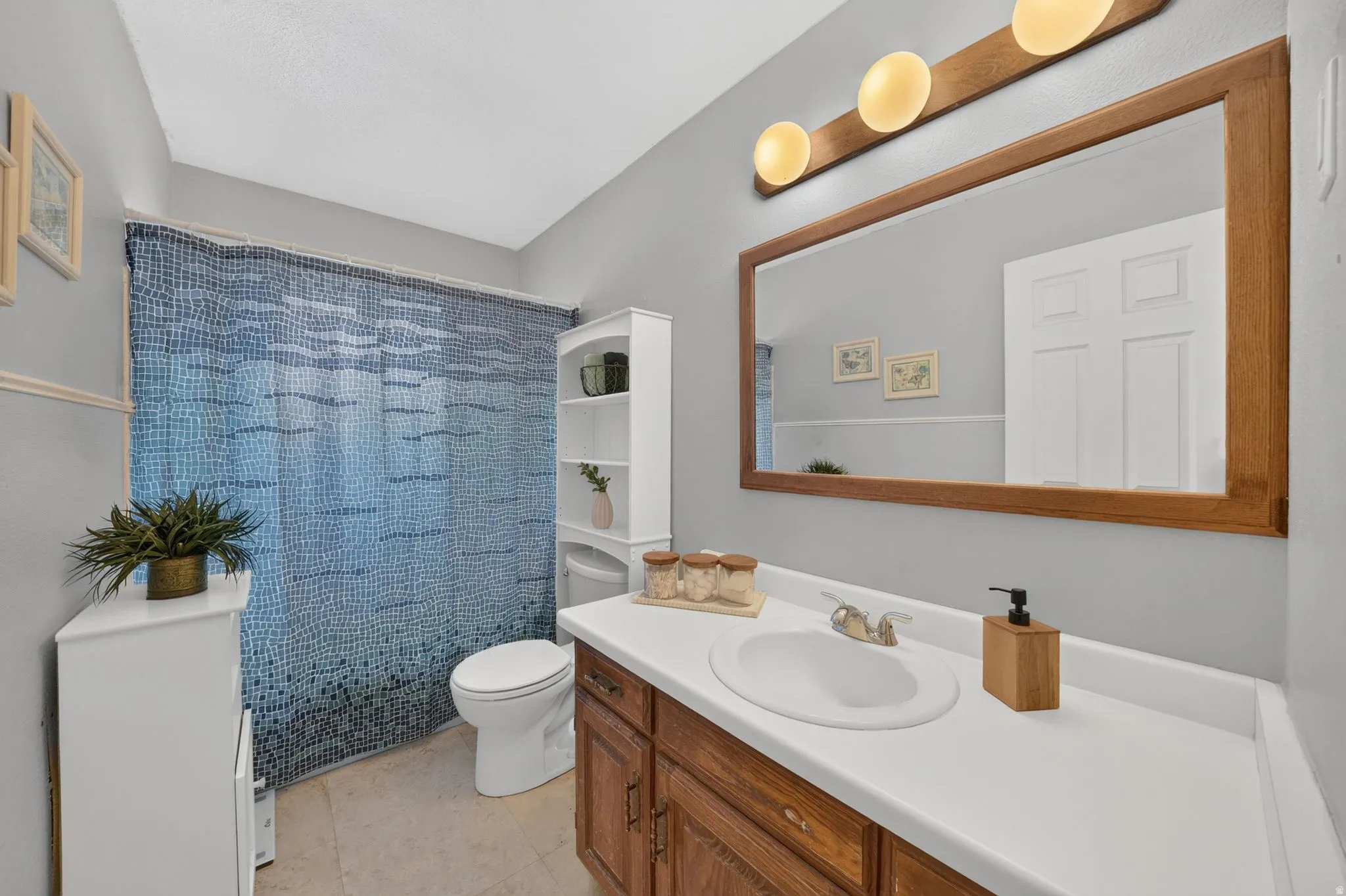 Bathroom featuring a single vanity with wood-finish cabinetry and a white countertop