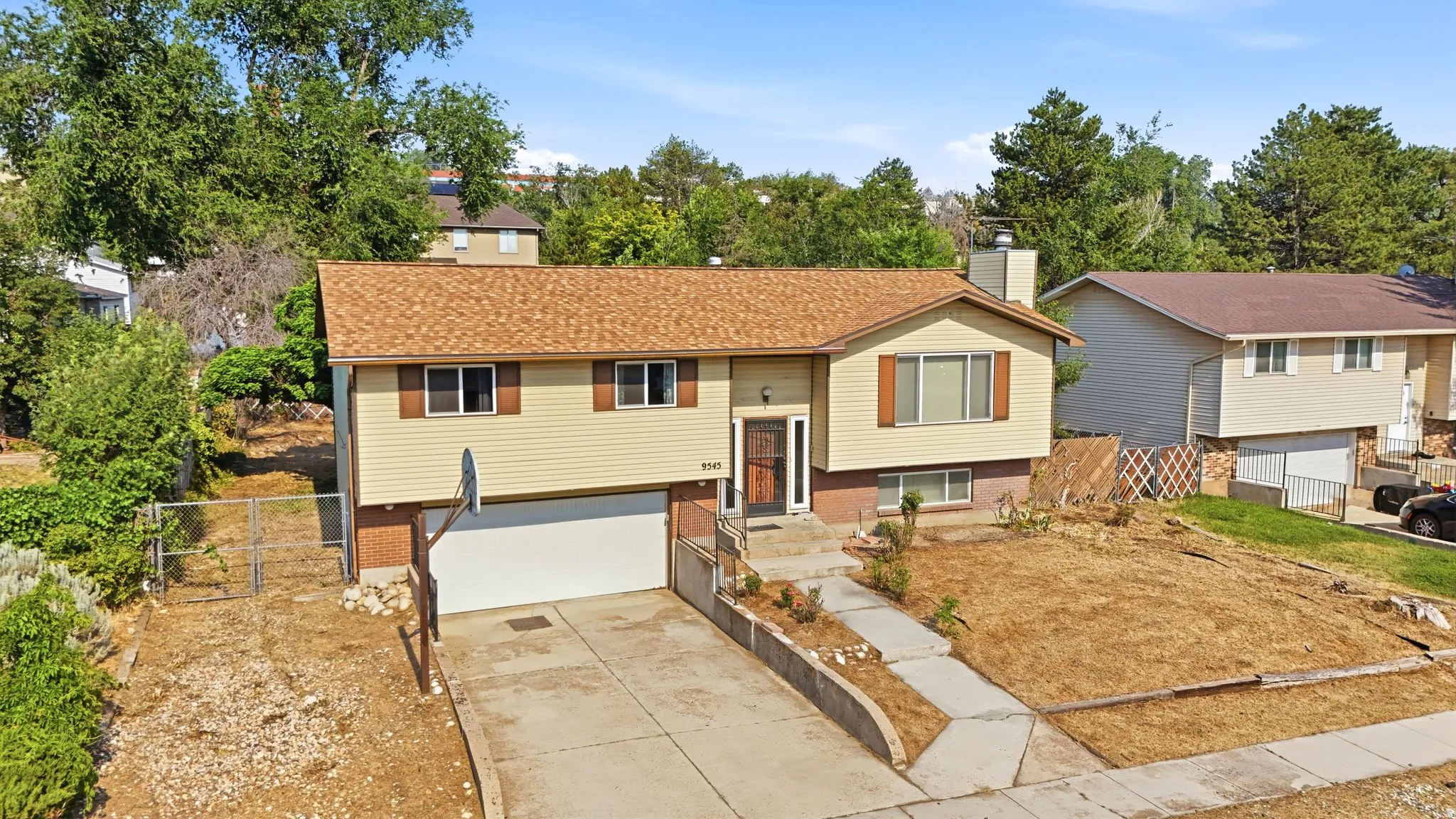 Split-level residence featuring a double-pane window, asphalt shingle roof, and attached garage