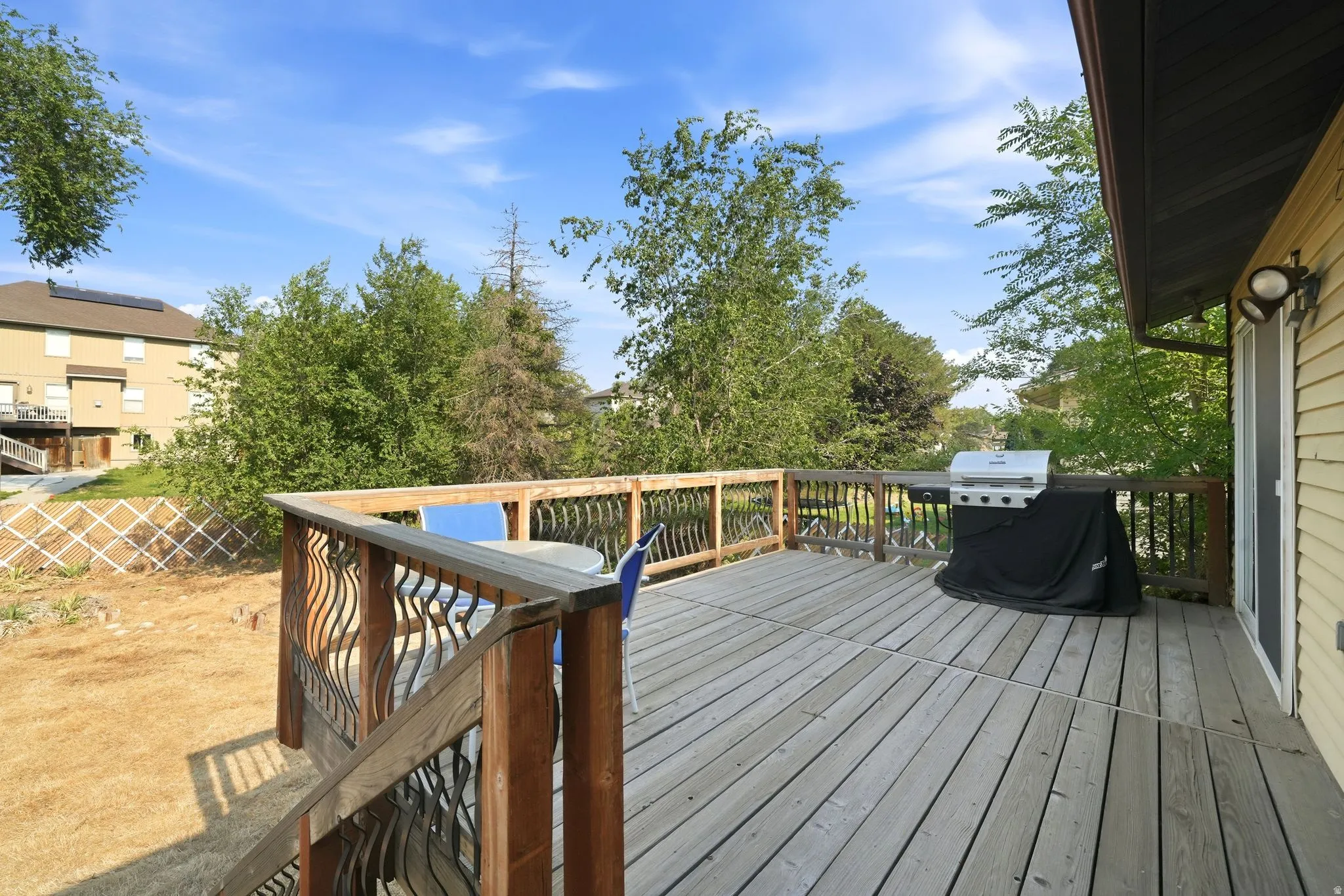 Spacious wood-finish deck with decorative metal balusters and wood railing