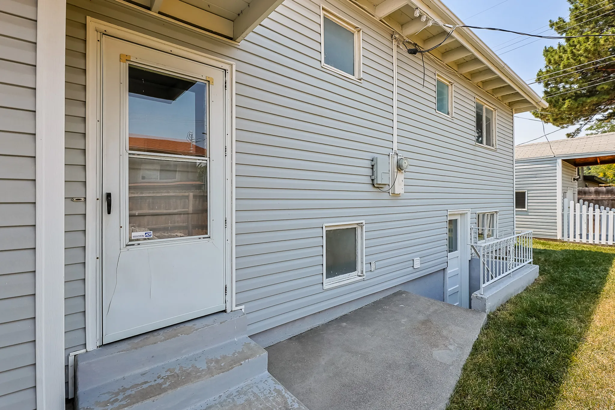 Exterior of home with 2 walk out doors to sideyard.